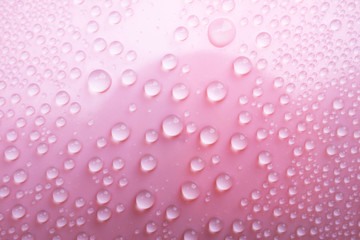 Water droplet on pink texture surface.