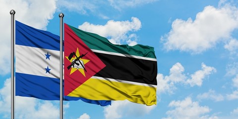 Honduras and Mozambique flag waving in the wind against white cloudy blue sky together. Diplomacy concept, international relations.