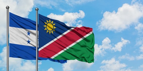 Honduras and Namibia flag waving in the wind against white cloudy blue sky together. Diplomacy...