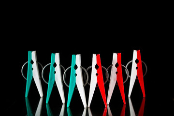 A lot of multi-colored clothespins on a black background.