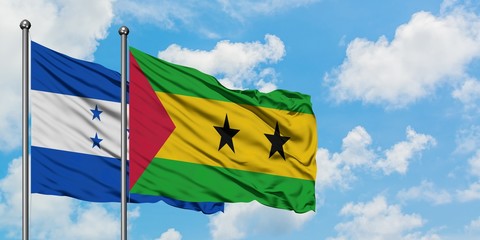 Honduras and Sao Tome And Principe flag waving in the wind against white cloudy blue sky together....