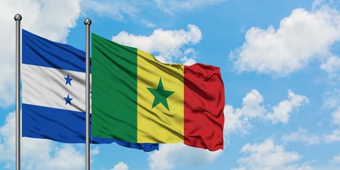 Honduras and Senegal flag waving in the wind against white cloudy blue sky together. Diplomacy concept, international relations.