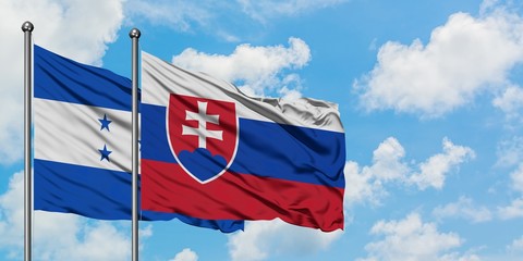 Honduras and Slovakia flag waving in the wind against white cloudy blue sky together. Diplomacy concept, international relations.