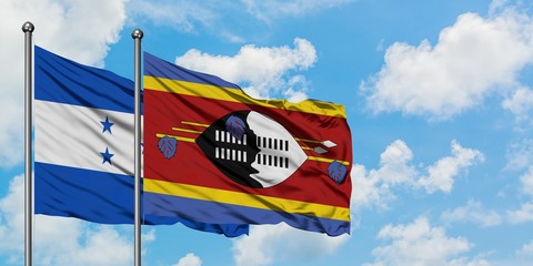 Honduras and Swaziland flag waving in the wind against white cloudy blue sky together. Diplomacy...