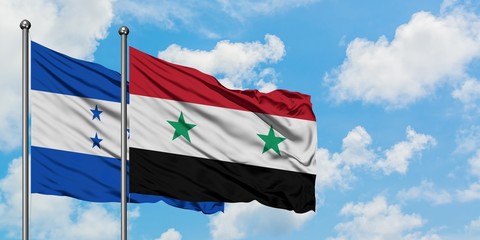 Honduras and Syria flag waving in the wind against white cloudy blue sky together. Diplomacy concept, international relations.