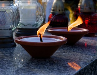 burning lights on tomb in cemetery