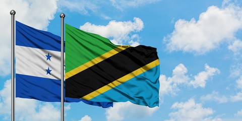 Honduras and Tanzania flag waving in the wind against white cloudy blue sky together. Diplomacy concept, international relations.