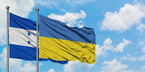 Honduras and Ukraine flag waving in the wind against white cloudy blue sky together. Diplomacy concept, international relations.