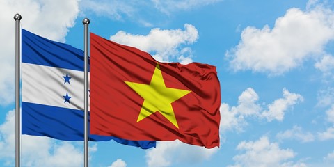 Honduras and Vietnam flag waving in the wind against white cloudy blue sky together. Diplomacy concept, international relations.