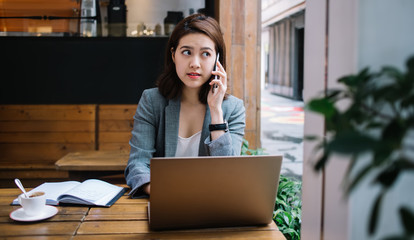 Young woman talking on phone in cafe