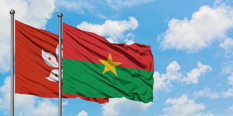 Hong Kong and Burkina Faso flag waving in the wind against white cloudy blue sky together. Diplomacy concept, international relations.