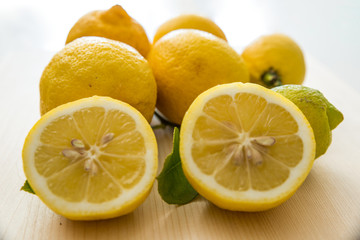Fototapeta na wymiar limoni tagliati su tagliere bianco