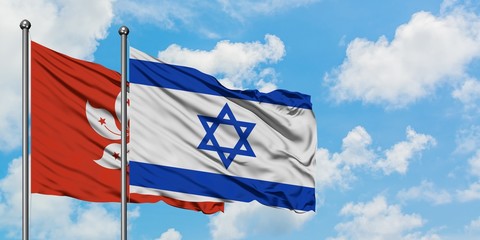 Hong Kong and Israel flag waving in the wind against white cloudy blue sky together. Diplomacy concept, international relations.