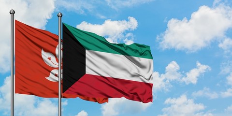 Hong Kong and Kuwait flag waving in the wind against white cloudy blue sky together. Diplomacy concept, international relations.