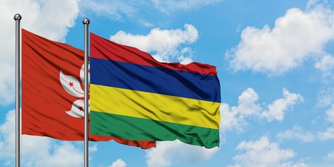 Hong Kong and Mauritius flag waving in the wind against white cloudy blue sky together. Diplomacy concept, international relations.