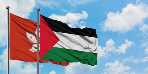 Hong Kong and Palestine flag waving in the wind against white cloudy blue sky together. Diplomacy concept, international relations.