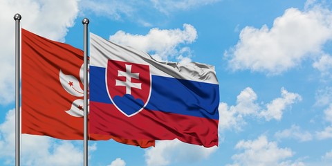 Hong Kong and Slovakia flag waving in the wind against white cloudy blue sky together. Diplomacy concept, international relations.