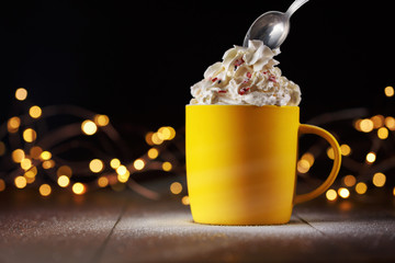 cup with a drink and whipped cream. background with light bulbs.