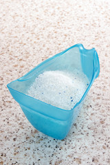 Laundry detergent or washing powder in a plastic measuring 