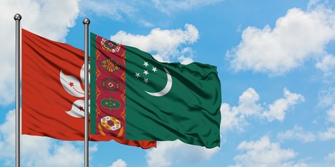 Hong Kong and Turkmenistan flag waving in the wind against white cloudy blue sky together....