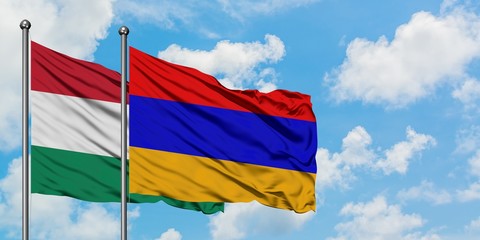 Hungary and Armenia flag waving in the wind against white cloudy blue sky together. Diplomacy concept, international relations.