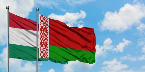 Hungary and Belarus flag waving in the wind against white cloudy blue sky together. Diplomacy concept, international relations.