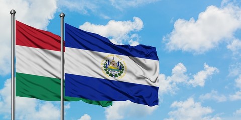 Hungary and El Salvador flag waving in the wind against white cloudy blue sky together. Diplomacy concept, international relations.