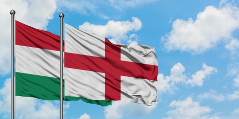 Hungary and England flag waving in the wind against white cloudy blue sky together. Diplomacy concept, international relations.