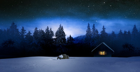 Gemütliche Holzhütte mit Beleuchtetem Fenster in Wnterwald bei Nacht im Winter