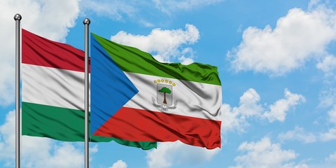 Hungary and Equatorial Guinea flag waving in the wind against white cloudy blue sky together. Diplomacy concept, international relations.