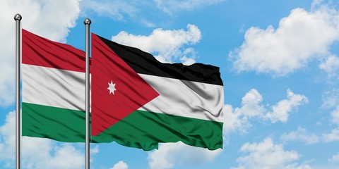 Hungary and Jordan flag waving in the wind against white cloudy blue sky together. Diplomacy concept, international relations.