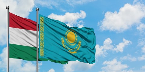 Hungary and Kazakhstan flag waving in the wind against white cloudy blue sky together. Diplomacy concept, international relations.