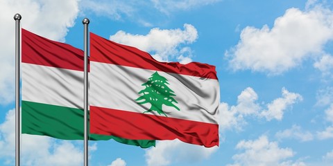 Hungary and Lebanon flag waving in the wind against white cloudy blue sky together. Diplomacy concept, international relations.