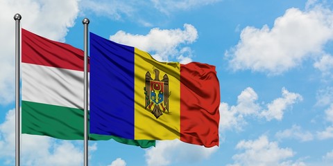 Hungary and Moldova flag waving in the wind against white cloudy blue sky together. Diplomacy concept, international relations.