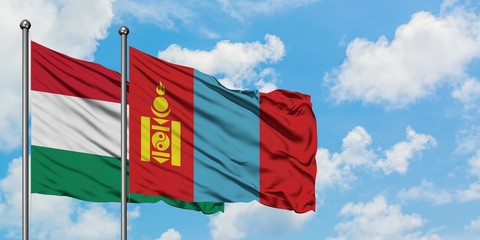 Hungary and Mongolia flag waving in the wind against white cloudy blue sky together. Diplomacy concept, international relations.