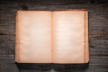Vintage book, open, on old wooden table, with clipping path. Open Book blank on old wooden...
