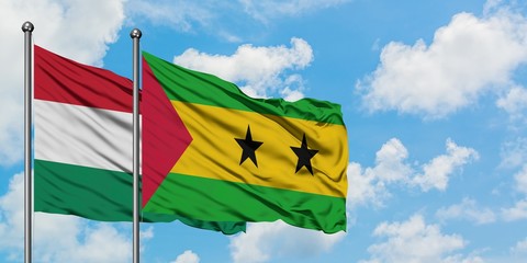 Hungary and Sao Tome And Principe flag waving in the wind against white cloudy blue sky together. Diplomacy concept, international relations.