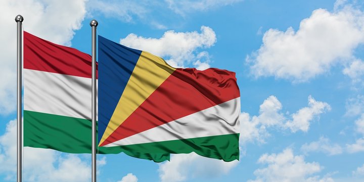 Hungary and Seychelles flag waving in the wind against white cloudy blue sky together. Diplomacy concept, international relations.