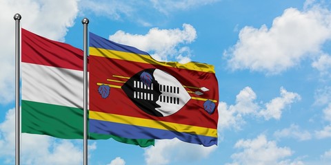 Hungary and Swaziland flag waving in the wind against white cloudy blue sky together. Diplomacy concept, international relations.