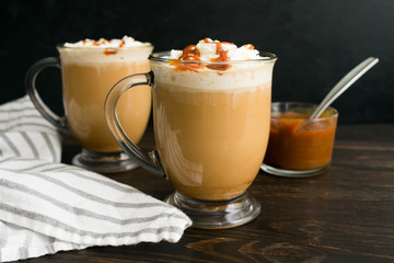 Coffee with milk topped with whipped cream and caramel sauce
