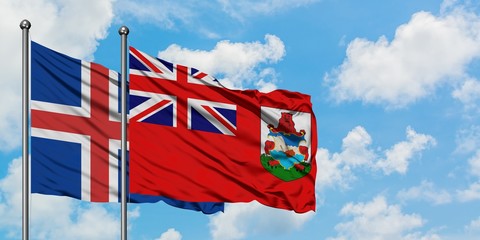Iceland and Bermuda flag waving in the wind against white cloudy blue sky together. Diplomacy...
