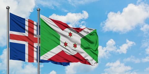 Iceland and Burundi flag waving in the wind against white cloudy blue sky together. Diplomacy...