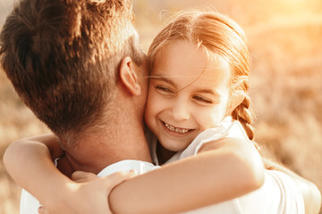 Happy daughter hugging father in nature