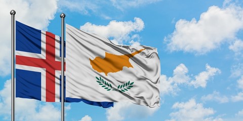 Iceland and Cyprus flag waving in the wind against white cloudy blue sky together. Diplomacy...