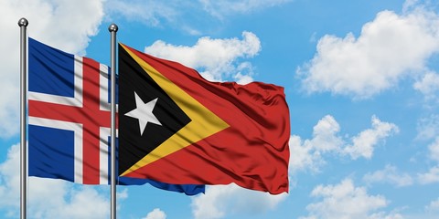 Iceland and East Timor flag waving in the wind against white cloudy blue sky together. Diplomacy concept, international relations.