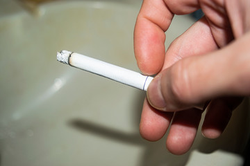 Cigarette in a man's hand concept photo. The dangers of Smoking. Healthy lifestyle. Rejection of bad habits.