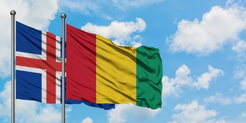 Iceland and Guinea flag waving in the wind against white cloudy blue sky together. Diplomacy concept, international relations.