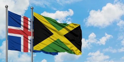 Iceland and Jamaica flag waving in the wind against white cloudy blue sky together. Diplomacy concept, international relations.