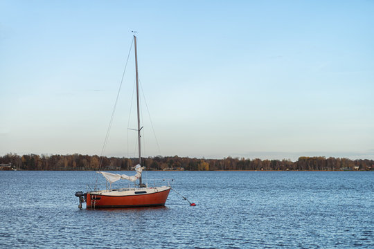 Image of red wooden boat on the autumn lake