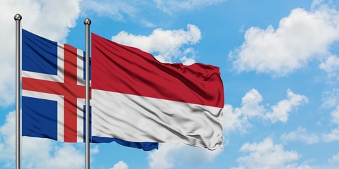 Iceland and Monaco flag waving in the wind against white cloudy blue sky together. Diplomacy concept, international relations.